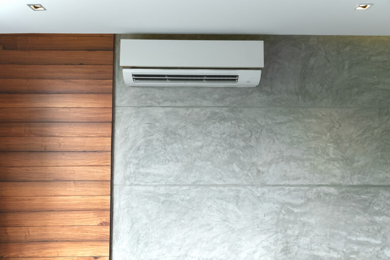 Living room with gray wall and wooden air conditioner on wall.